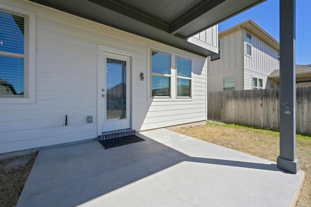 entrance to property featuring a patio and fence