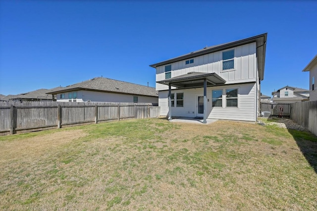 back of property featuring a lawn, board and batten siding, and a fenced backyard