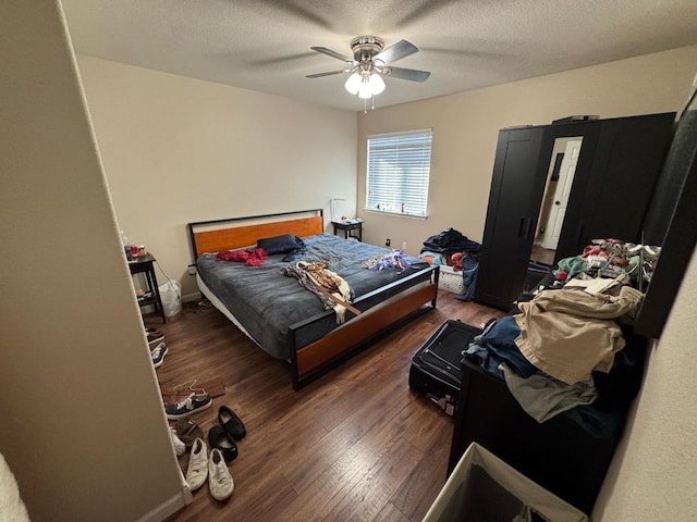 bedroom with baseboards, a textured ceiling, ceiling fan, and wood finished floors