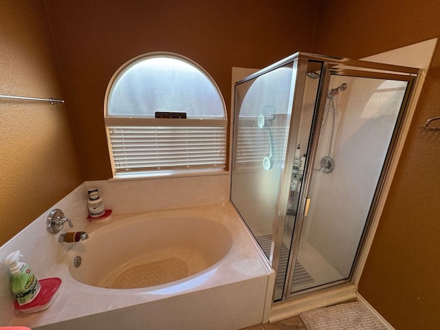 full bath featuring a stall shower and a garden tub