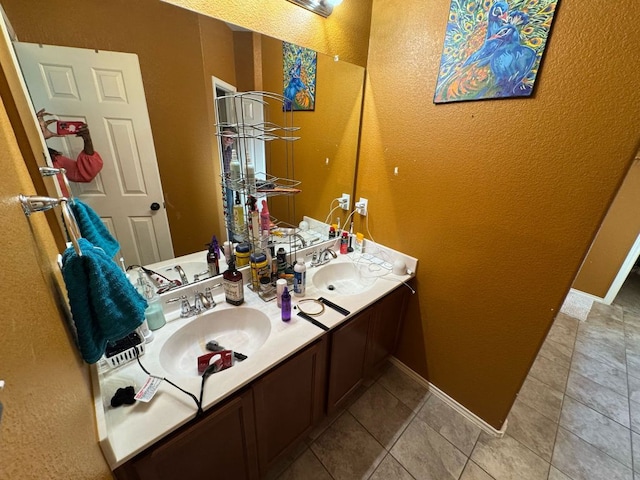 bathroom with double vanity, baseboards, and a sink