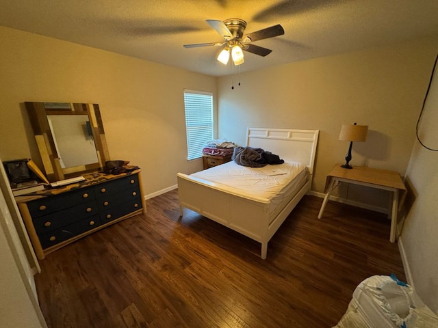 bedroom with baseboards, a textured ceiling, and dark wood finished floors