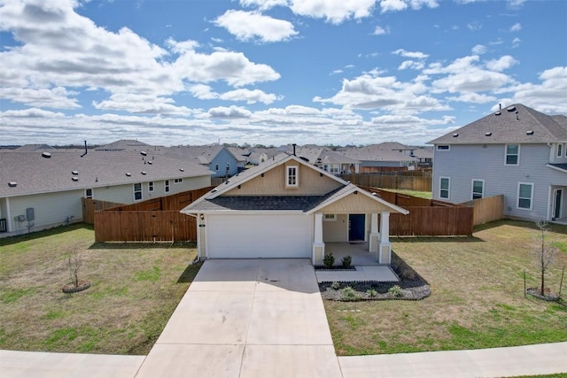 view of front of home featuring a shingled roof, fence, a residential view, a front yard, and driveway