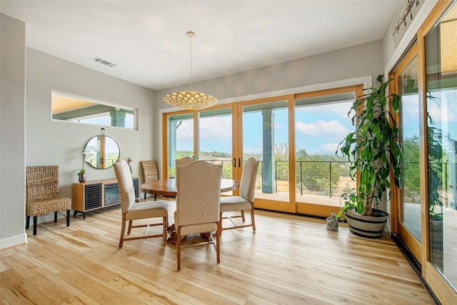 dining room featuring light wood-type flooring, visible vents, and french doors