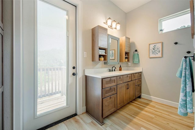 bathroom featuring vanity, wood finished floors, and baseboards