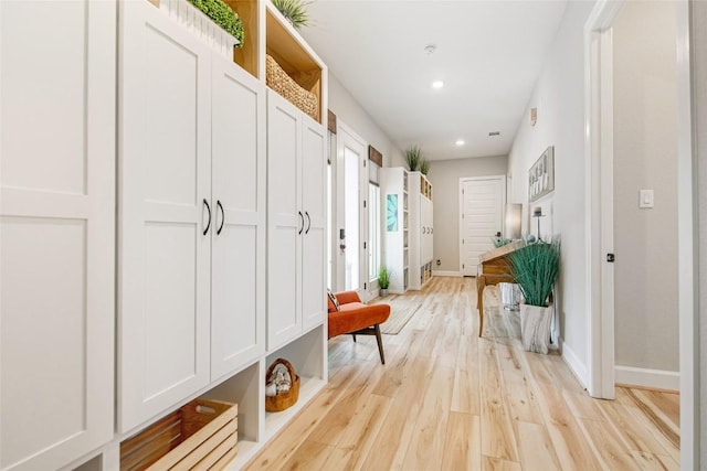 mudroom with light wood finished floors, recessed lighting, and baseboards