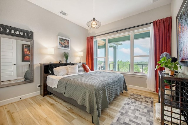 bedroom featuring light wood-type flooring, baseboards, and visible vents