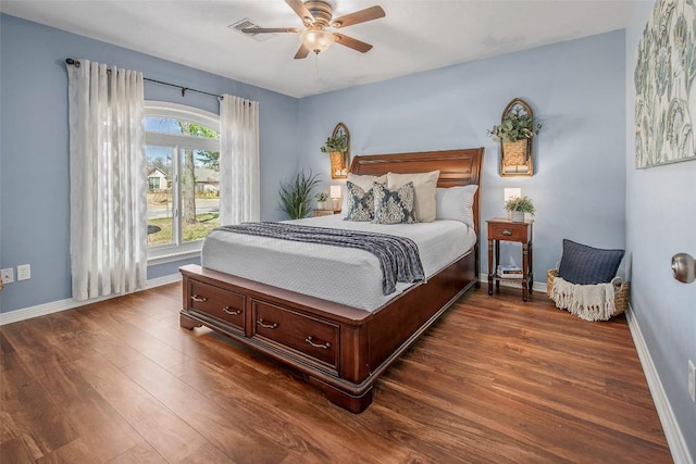 bedroom featuring visible vents, ceiling fan, dark wood-type flooring, and baseboards