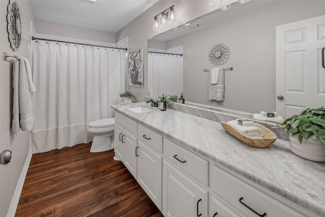 bathroom with vanity, curtained shower, toilet, and wood finished floors