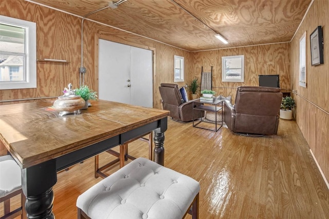 dining room with wooden walls and light wood-style floors