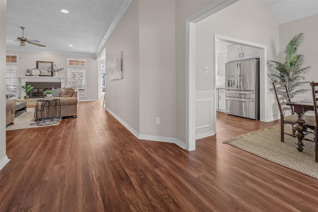 corridor with recessed lighting, ornamental molding, baseboards, and wood finished floors