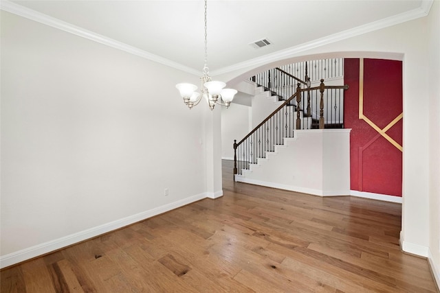 interior space with wood finished floors, arched walkways, visible vents, and ornamental molding