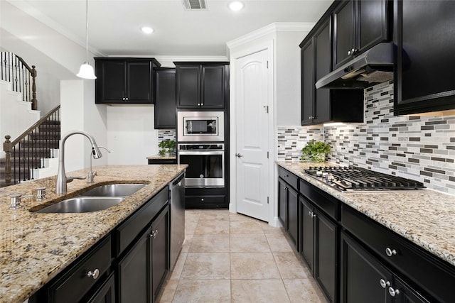 kitchen featuring under cabinet range hood, decorative backsplash, appliances with stainless steel finishes, dark cabinetry, and a sink