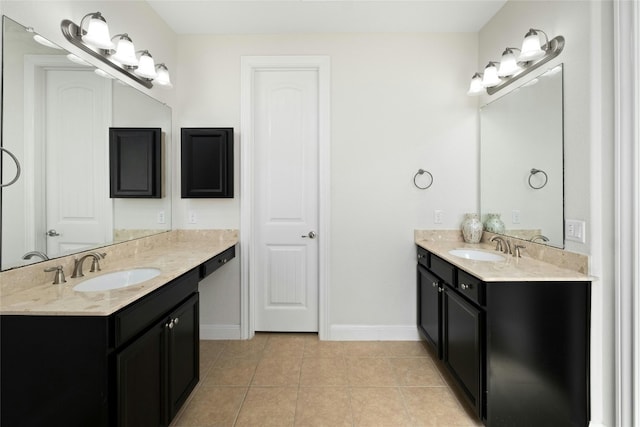 full bath featuring tile patterned floors, baseboards, two vanities, and a sink