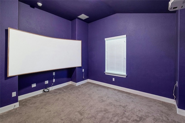 cinema room featuring a wall mounted air conditioner, baseboards, carpet flooring, and vaulted ceiling