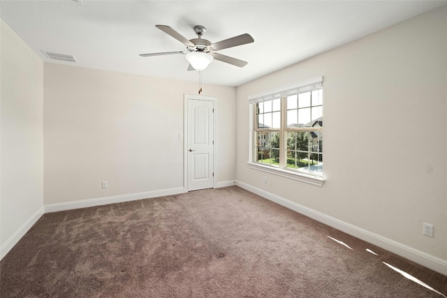 carpeted spare room with visible vents, ceiling fan, and baseboards