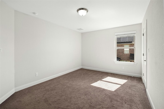 unfurnished room with visible vents, baseboards, and carpet