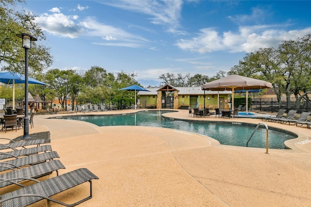 community pool featuring a patio area and fence