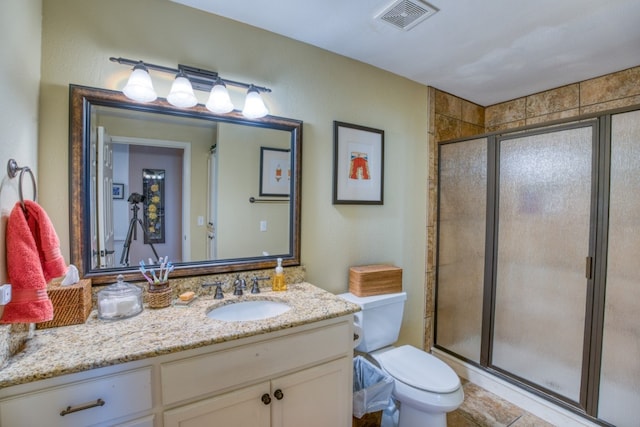 full bath with visible vents, vanity, a shower stall, and toilet