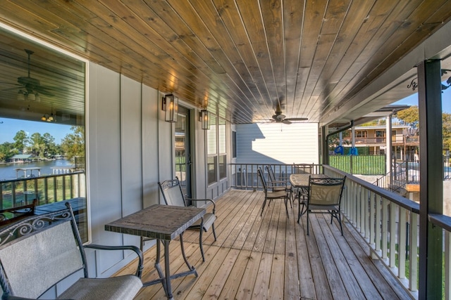 wooden deck featuring a ceiling fan and a water view