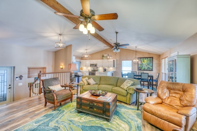 living area with lofted ceiling with beams, wood finished floors, and ceiling fan with notable chandelier