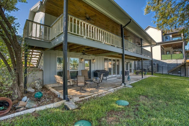 rear view of house featuring board and batten siding, ceiling fan, stairs, a yard, and a patio