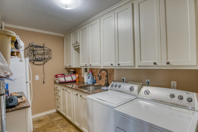 laundry room with crown molding, baseboards, separate washer and dryer, cabinet space, and a sink