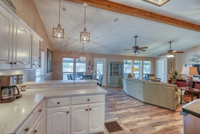 kitchen featuring vaulted ceiling with beams, pendant lighting, light wood-type flooring, a peninsula, and white cabinetry