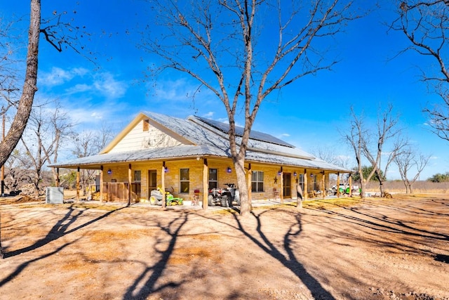 view of front of home with solar panels and a porch