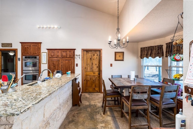 dining space featuring a chandelier and high vaulted ceiling