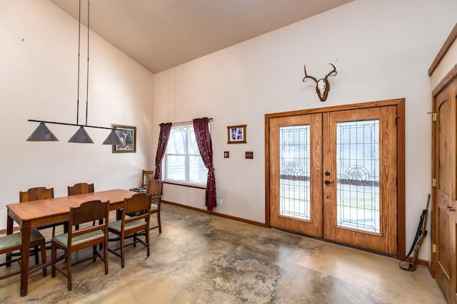 dining area featuring french doors, baseboards, concrete floors, and vaulted ceiling