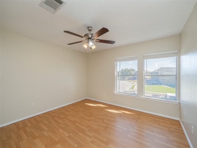 empty room with visible vents, baseboards, ceiling fan, and light wood finished floors