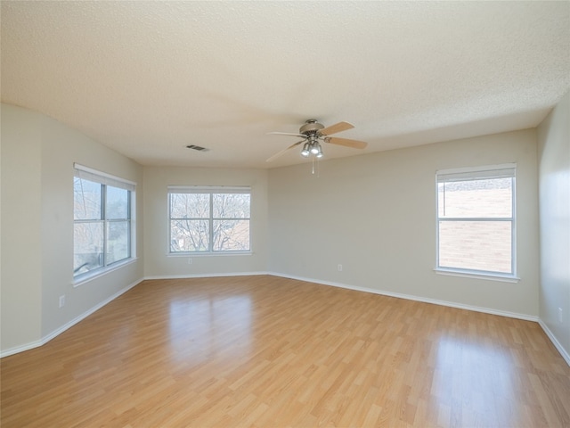 spare room with visible vents, baseboards, ceiling fan, a textured ceiling, and light wood-type flooring