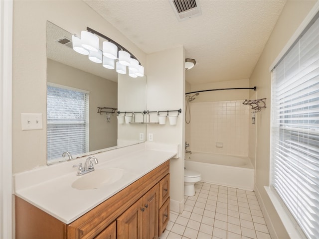 full bathroom featuring tile patterned floors, toilet, a wealth of natural light, and a textured ceiling