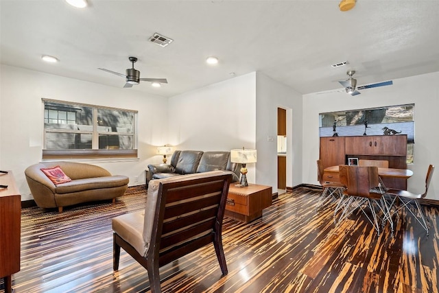 living area featuring wood finished floors, a ceiling fan, and visible vents