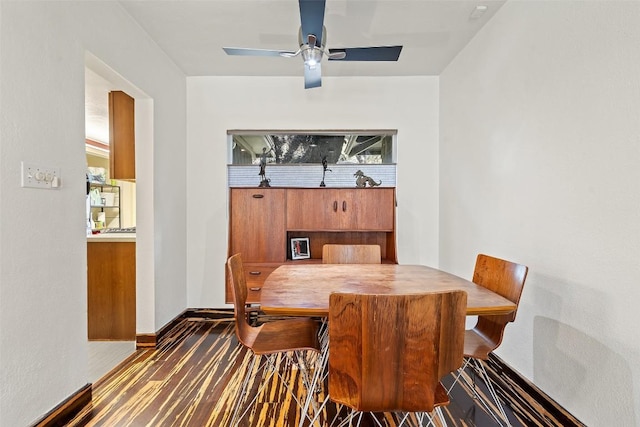 dining space featuring ceiling fan, baseboards, and wood finished floors