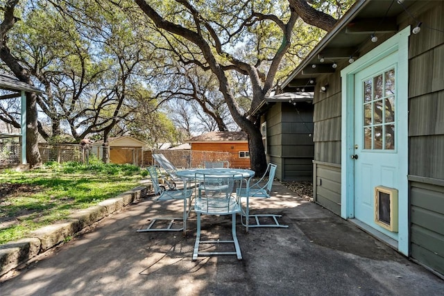 view of patio featuring outdoor dining space and fence