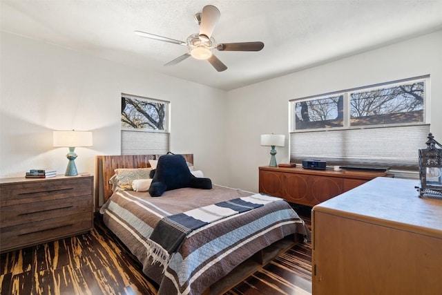 bedroom with multiple windows, a ceiling fan, and wood finished floors