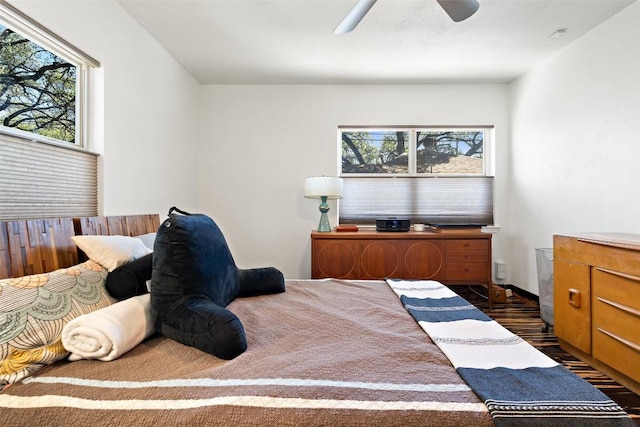 bedroom featuring dark wood finished floors, multiple windows, and a ceiling fan