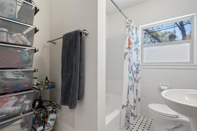 bathroom featuring tile patterned floors, toilet, tile walls, and shower / bath combination with curtain