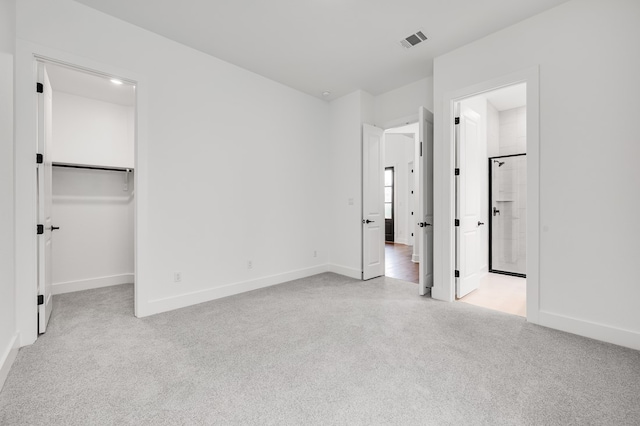 1821 Novara Trl, Leander, TX 78641 - unfurnished bedroom featuring carpet floors, baseboards, a walk in closet, and ensuite bath