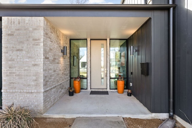 view of exterior entry featuring brick siding