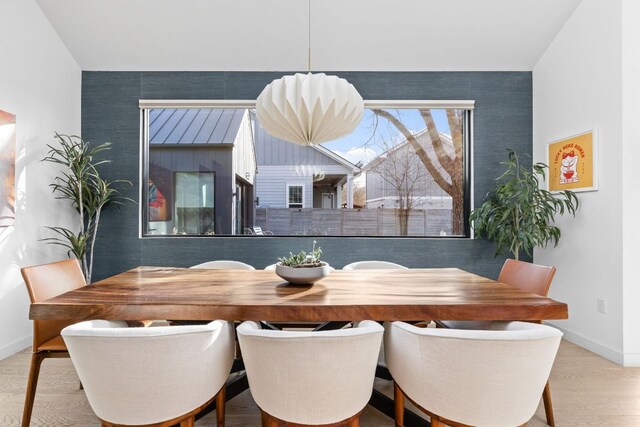 dining area with baseboards and wood finished floors