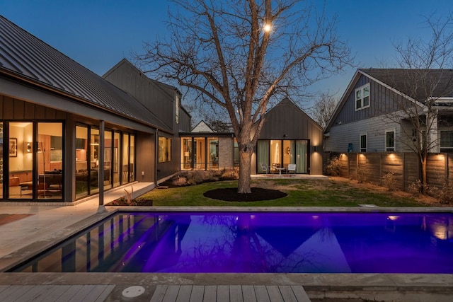 view of pool featuring a patio area, a yard, a fenced in pool, and fence