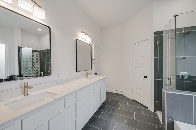 full bathroom featuring tile patterned floors, a stall shower, double vanity, and a sink