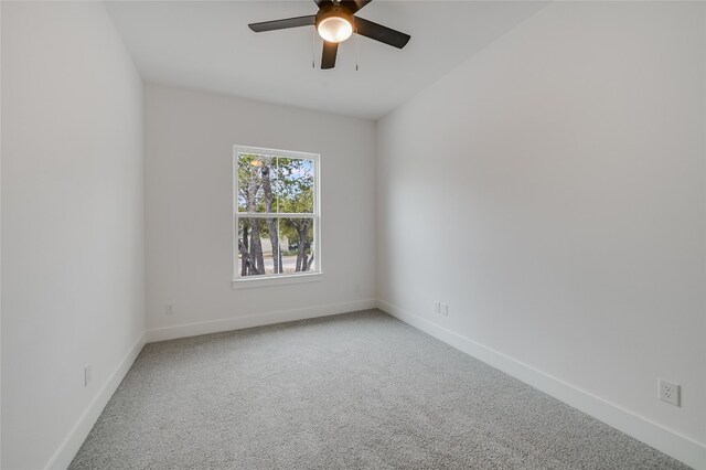 carpeted empty room featuring a ceiling fan and baseboards