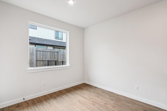 empty room featuring baseboards and wood finished floors