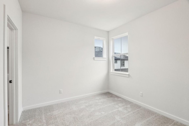 carpeted spare room featuring baseboards