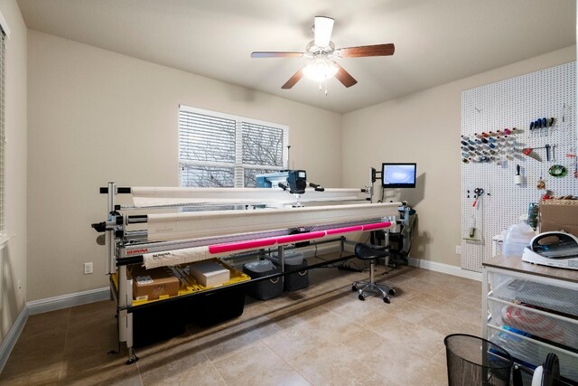 interior space with a ceiling fan and baseboards