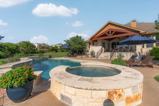 pool featuring a patio area and an in ground hot tub